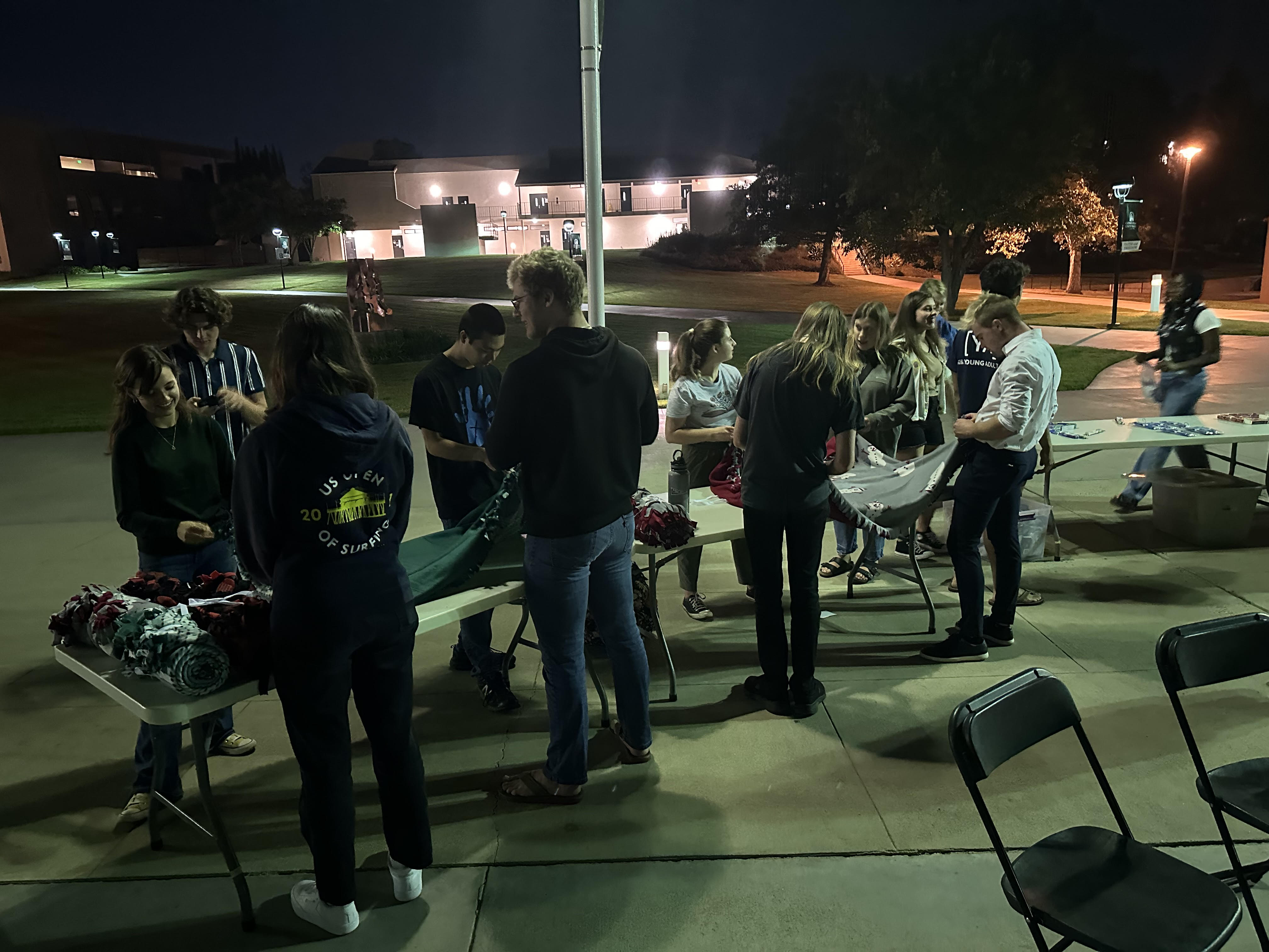 Students writing cards on tables at SHOUT tailgate in front of CU Center. 